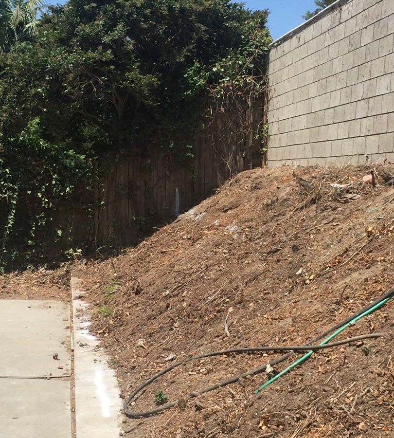 Old sloped hill where a new retaining wall will be built to create more flatspace in the backyard and safety. Pacificland Constructors