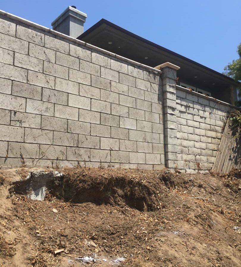 Old sloped hill where a new retaining wall will be built to create more flatspace in the backyard and safety. The freestanding wall’s footing began to get exposed and this worried our client so he took action by calling us for a new retaining wall. Pacificland Constructors