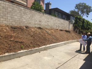 Old sloped hill where a new retaining wall will be built to create more flatspace in the backyard and safety. The freestanding wall’s footing began to get exposed and this worried our client so he took action by calling us for a new retaining wall. Pacificland Constructors