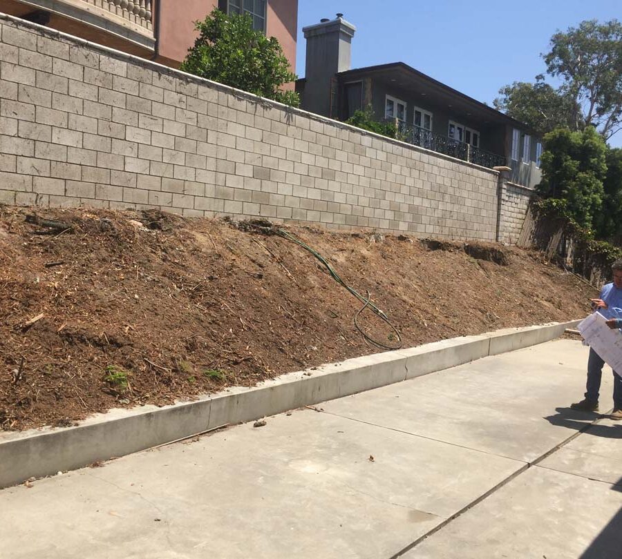 Old sloped hill where a new retaining wall will be built to create more flatspace in the backyard and safety. The freestanding wall’s footing began to get exposed and this worried our client so he took action by calling us for a new retaining wall. Pacificland Constructors