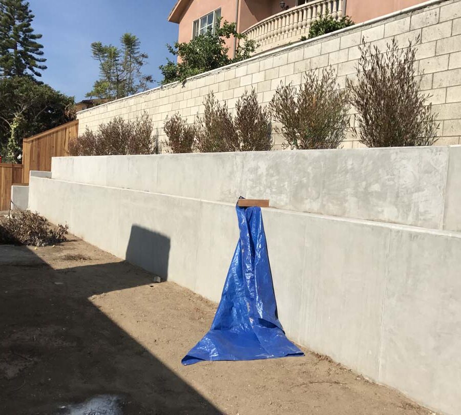 New pour in place concrete retaining wall for a backyard in Huntington Beach, CA. This retaining wall creates more flat area for the home because it holds up the differential earth elevation from the neighbor’s home. Pacificland Constructors