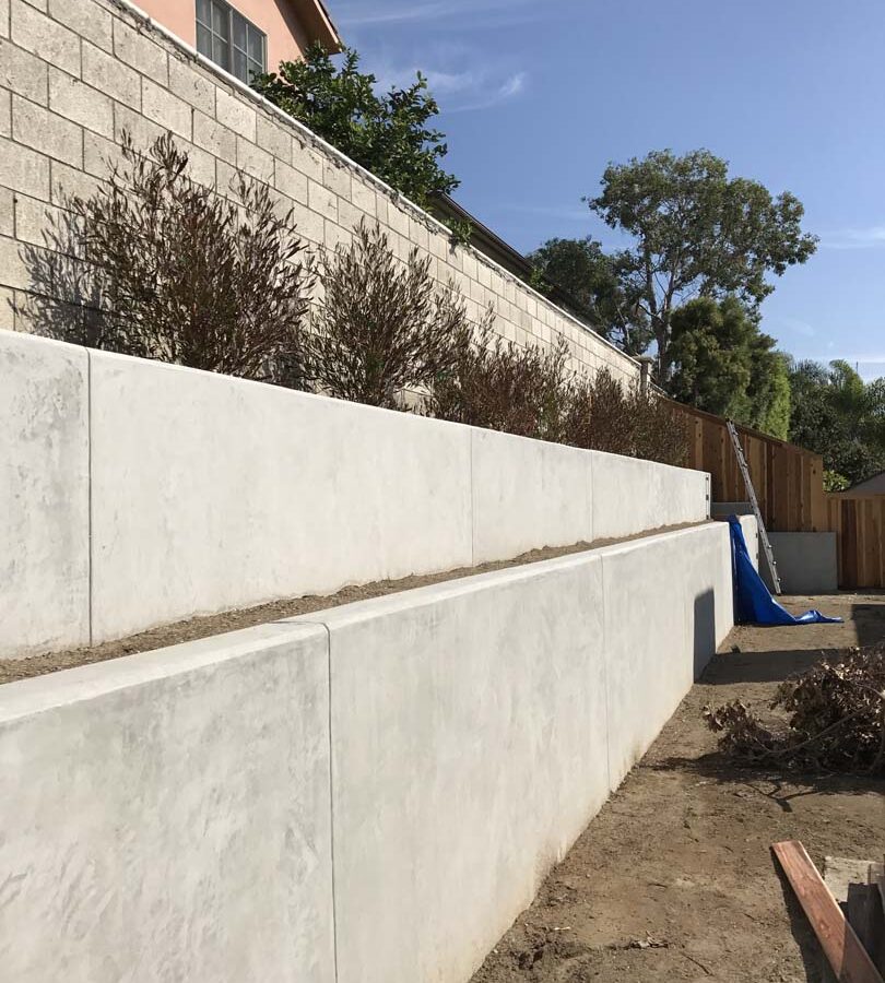 New pour in place concrete retaining wall for a backyard in Huntington Beach, CA. This retaining wall creates more flat area for the home because it holds up the differential earth elevation from the neighbor’s home. It also creates a planter for vegetation. Pacificland Constructors