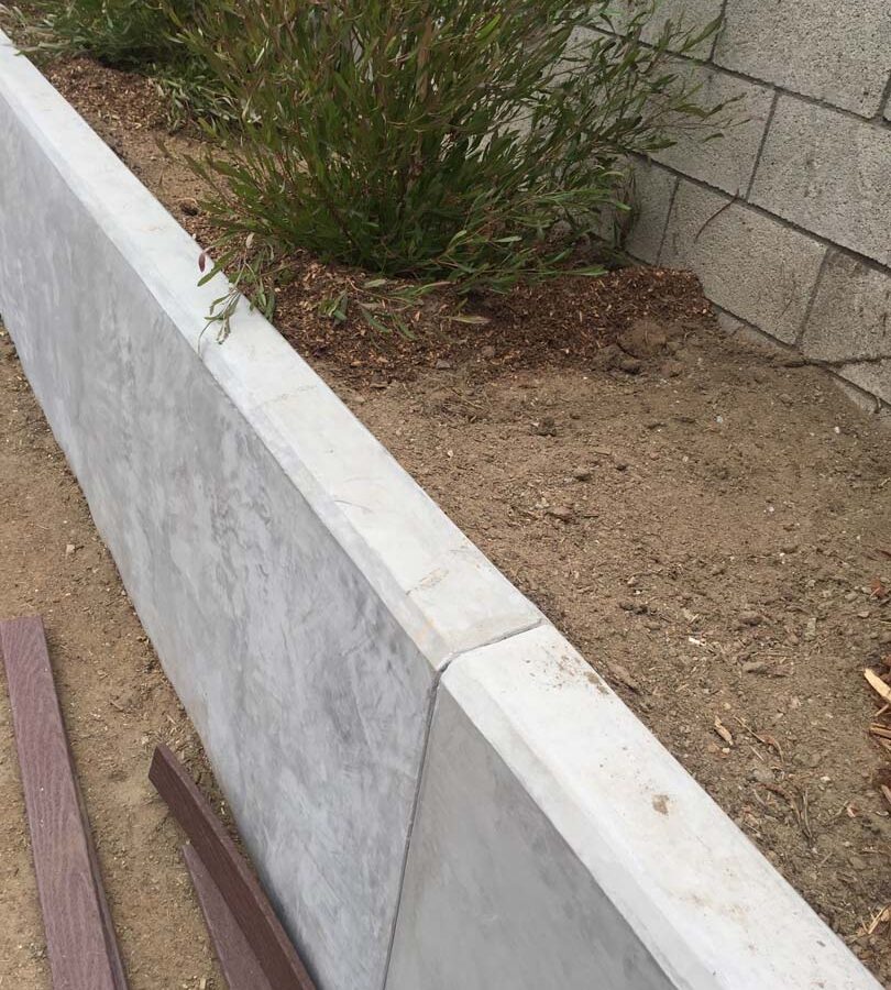 New pour in place concrete retaining wall for a backyard in Huntington Beach, CA. This retaining wall creates more flat area for the home because it holds up the differential earth elevation from the neighbor’s home. It also creates a planter for vegetation. Pacificland Constructors