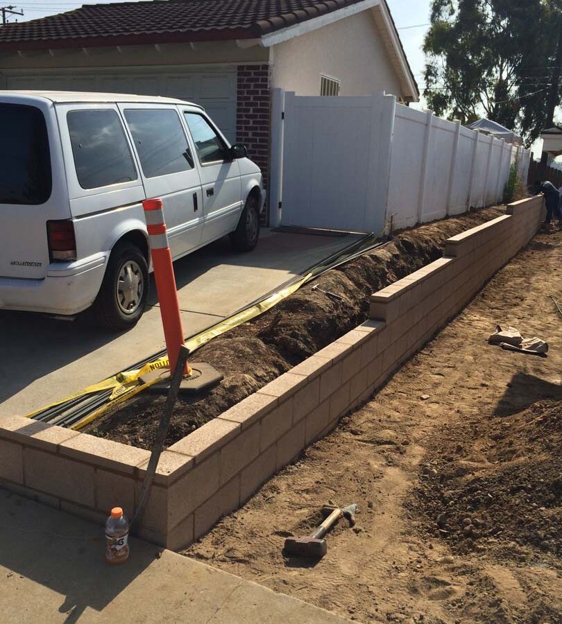 Construction for a new tan precision block retaining wall. Pacificland Constructors