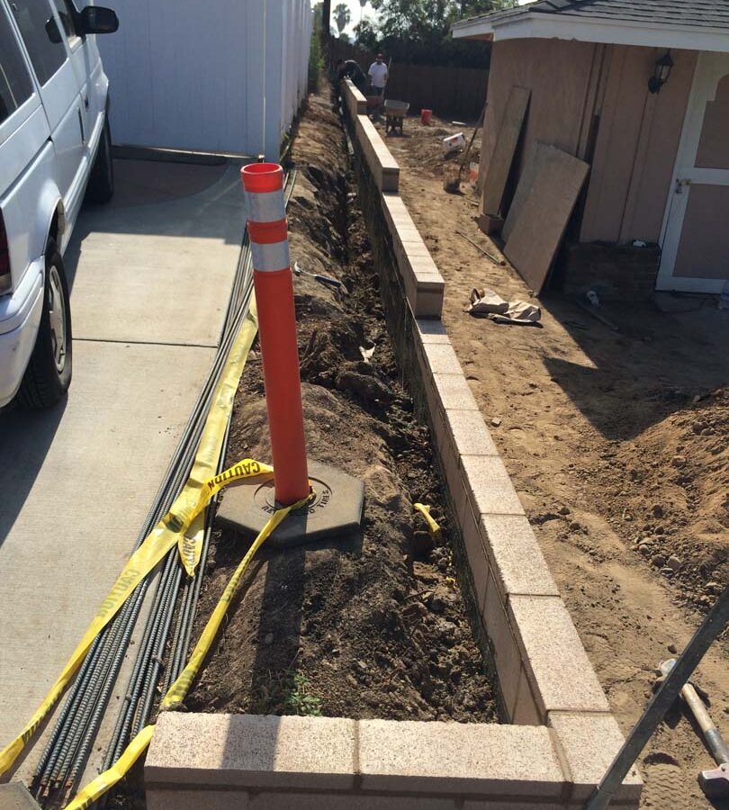 Construction for a new tan precision block retaining wall. Pacificland Constructors