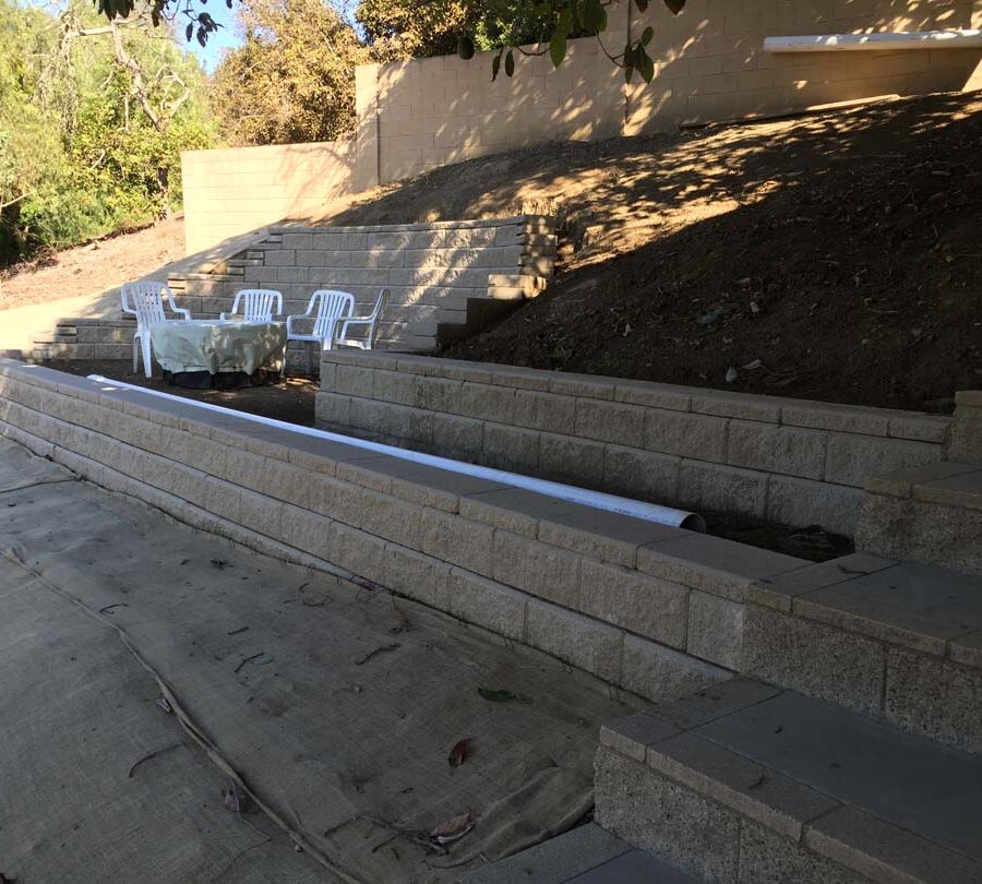 All retaining walls have a drainage system installed and buried in the soil behind the soil it is holding back. Pacificland Constructors