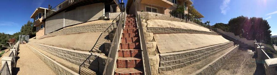 Panoramic view of new cmu retaining walls and brick steps. Pacificland Constructors