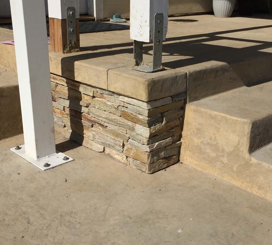 Colored stamped concrete with handmade joints. The steps also have the stamped texture and the porch face has stone veneer. Pacificland Constructors