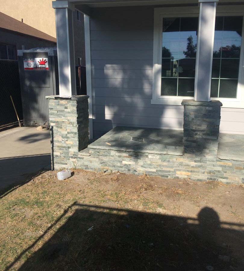 Flagstone flatwork at the entrance of a home. Artificial stone covered pilasters to create a modern theme. Pacificland Constructors