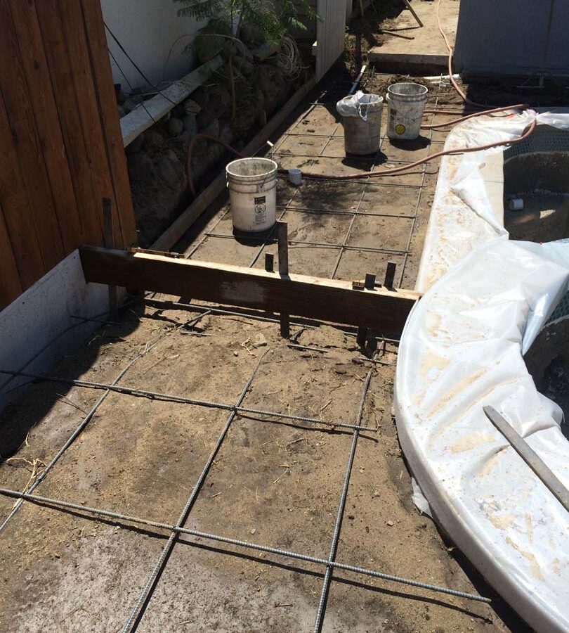 Steel reinforcement and pouring of a new gray concrete deck. We installed a water drainage system to make sure any rainfall or excess water drains out quickly to avoid slipping when using the pool. Pacificland Constructors