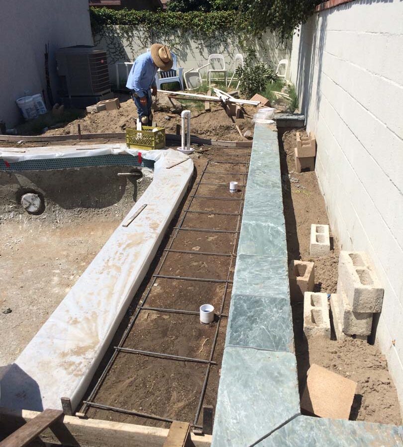 Steel reinforcement and pouring of a new gray concrete deck. We installed a water drainage system to make sure any rainfall or excess water drains out quickly to avoid slipping when using the pool. Pacificland Constructors