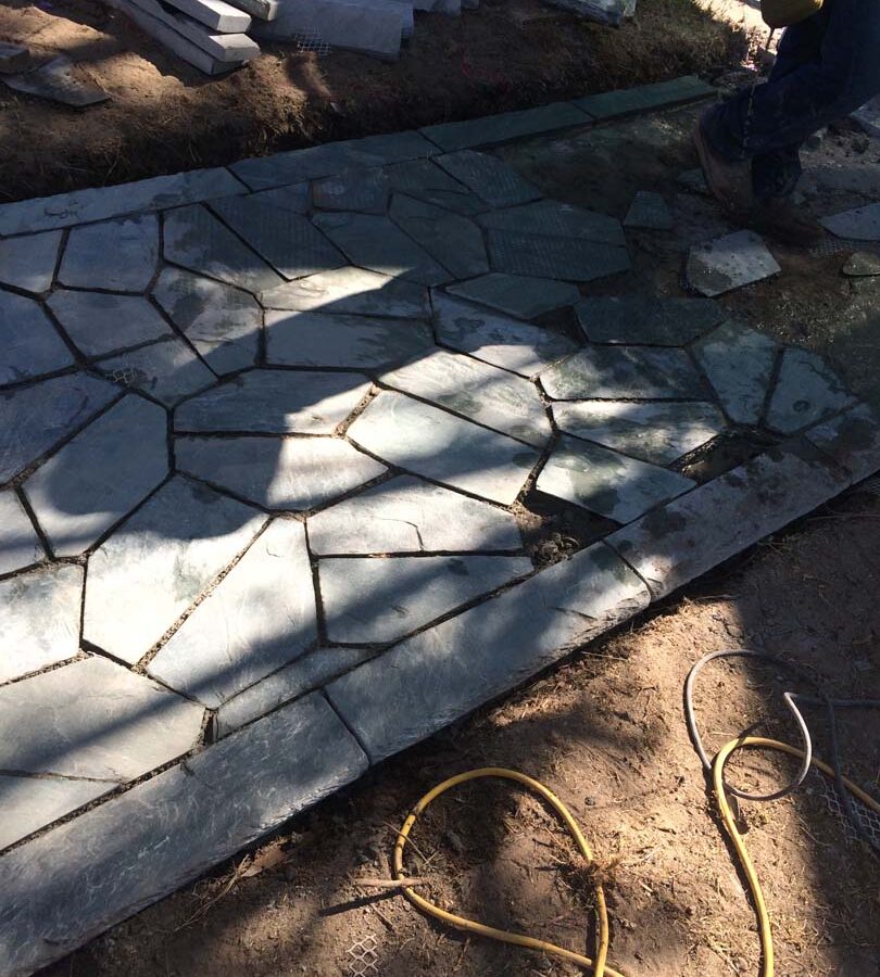 Construction of flagstone walkway. Each piece was hand cut and fixed in place. Pacificland Constructors