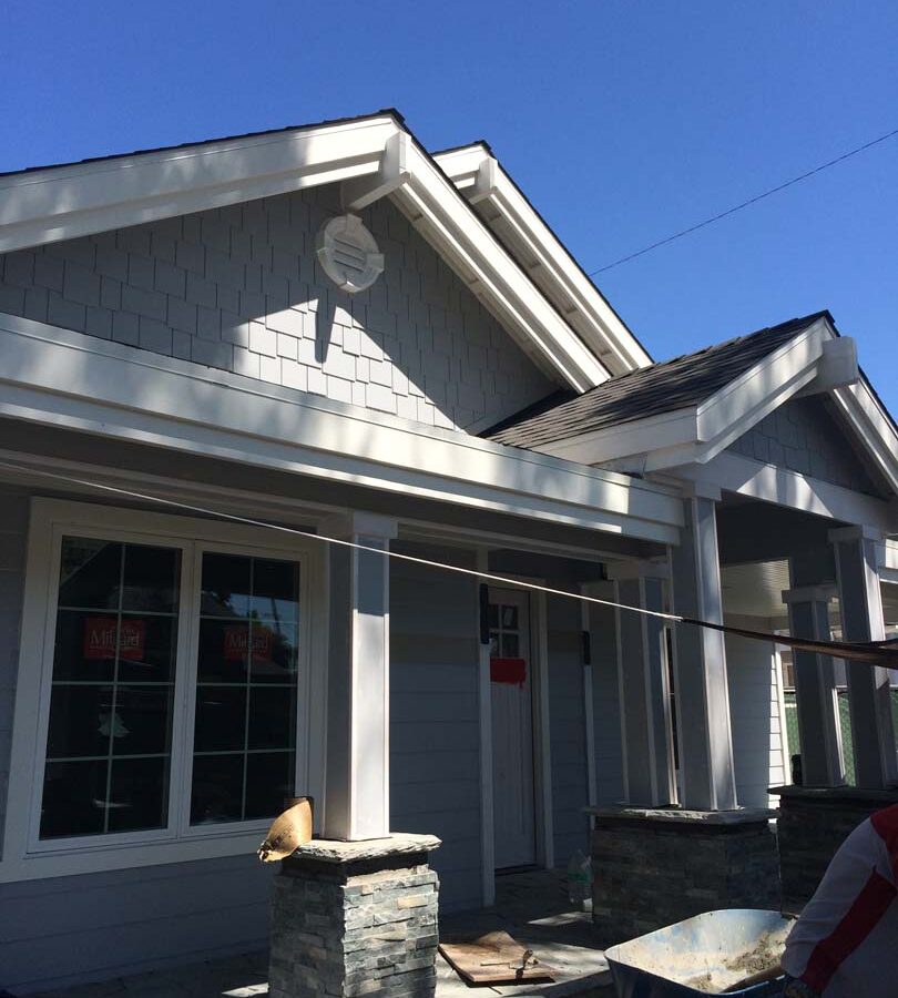 Construction of Flagstone flatwork at the entrance of a home. Artificial stone covered pilasters are intended to create a modern theme. Pacificland Constructors