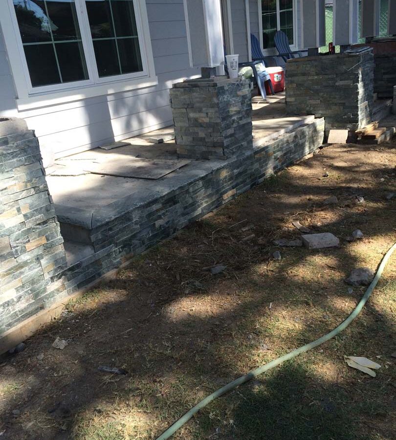 Construction of Flagstone flatwork at the entrance of a home. Artificial stone covered pilasters are intended to create a modern theme. Pacificland Constructors