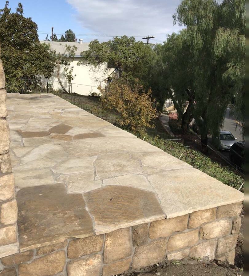 Stone covered pilasters and walls that match flagstone flatwork. Pacificland Constructors